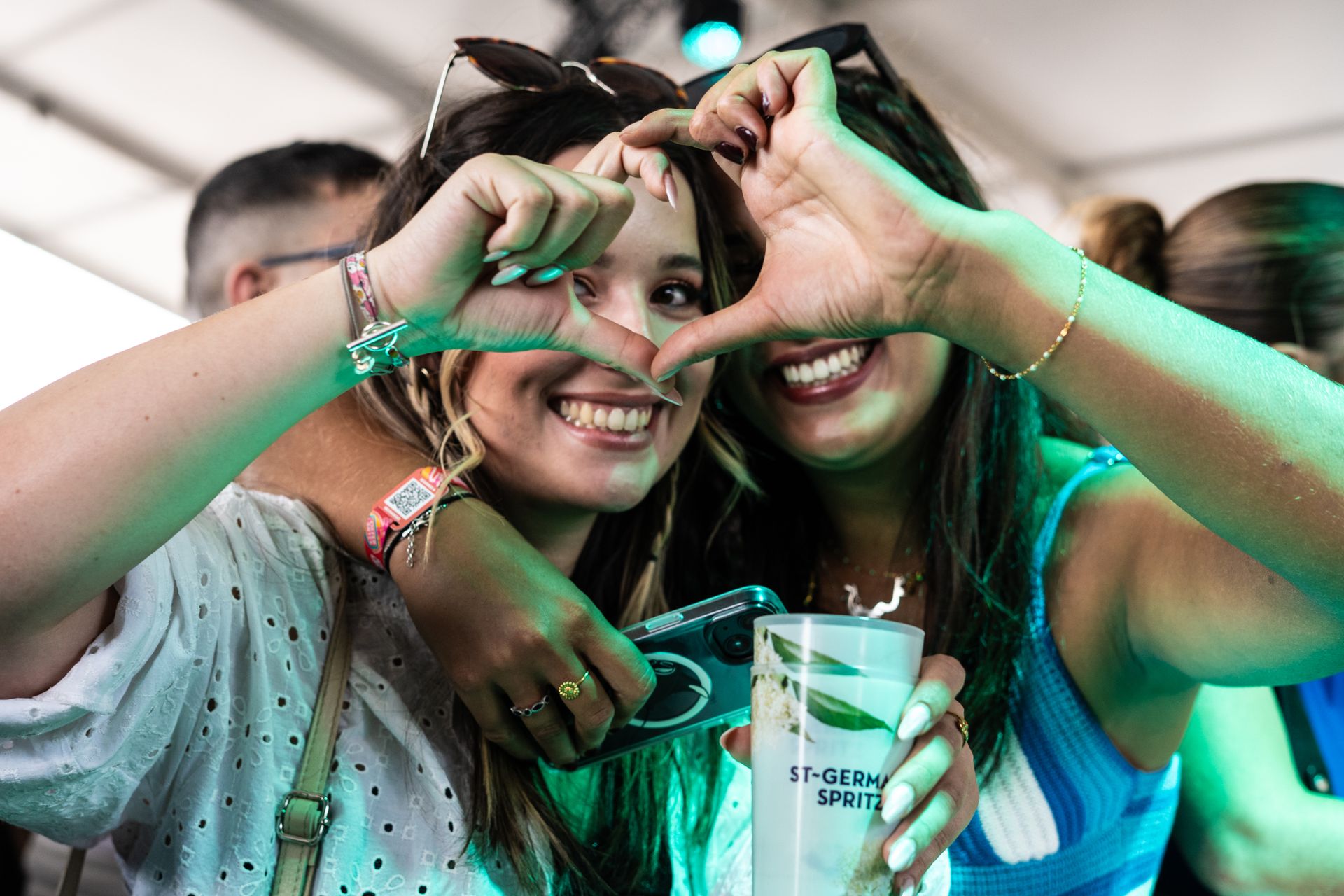 deux festivalières font un cœur avec leurs mains aux déferlantes